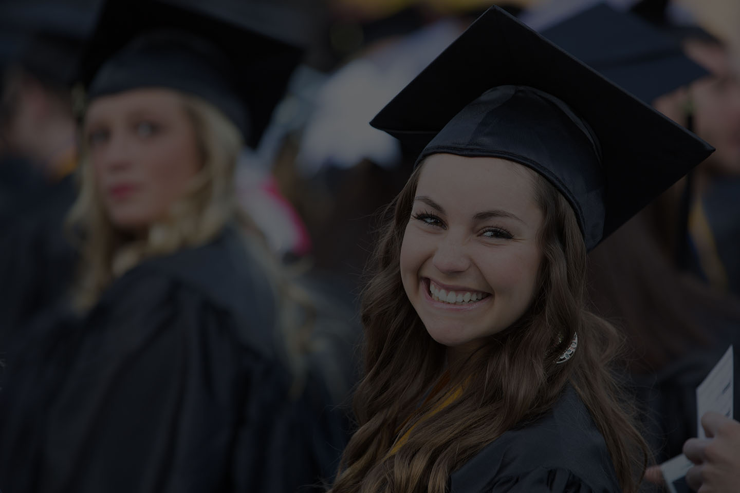 Close up of a smiling graduate wearing a cap and gown